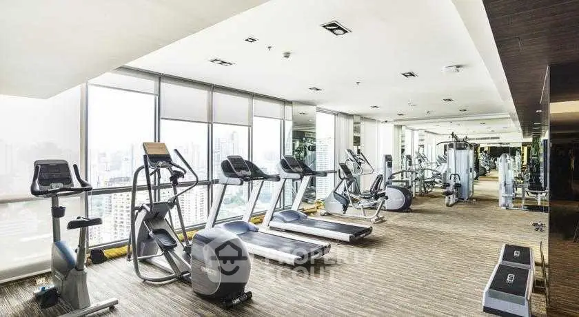 Spacious modern gym with city view in luxury residential building