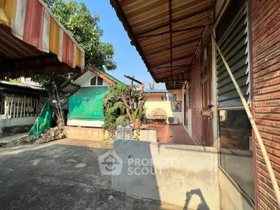 Charming rustic exterior with covered patio and lush greenery, perfect for outdoor relaxation.