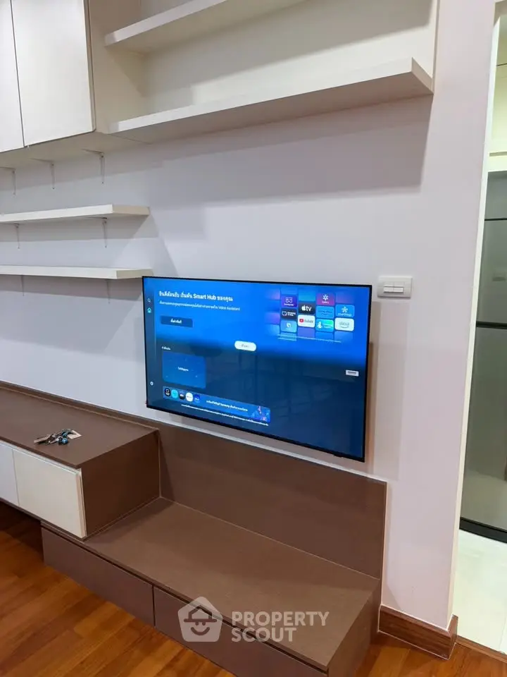 Modern living room with wall-mounted TV and sleek wooden cabinetry