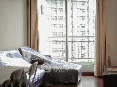 Modern living room with large windows and city view, featuring stylish furniture and elegant curtains.
