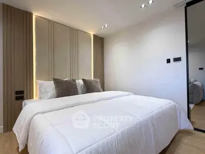 Modern bedroom with stylish lighting and cozy bedding in a contemporary apartment.