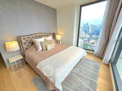Luxurious bedroom with stunning city view and elegant decor in high-rise apartment.