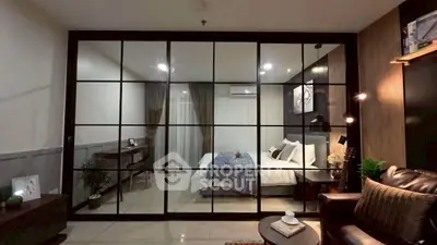 Modern living room with glass partition leading to a cozy bedroom, featuring stylish decor and ambient lighting.