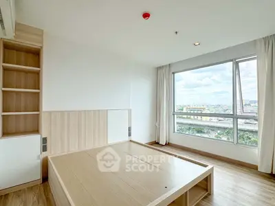 Spacious bedroom with large window offering stunning city views, featuring modern wooden flooring and built-in storage.