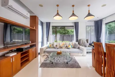 Spacious living room with modern decor and large windows offering garden views.