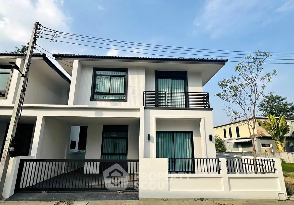 Modern two-story house with sleek design and spacious balcony in a serene neighborhood.