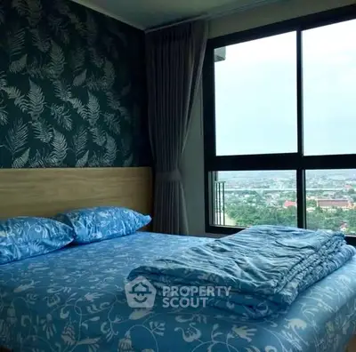 Spacious bedroom with large window offering stunning city view and elegant decor.