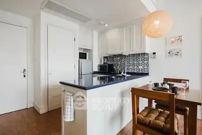 Charming kitchen with modern island and cozy dining area, perfect for intimate meals.