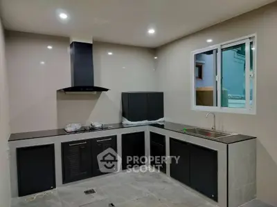 Modern kitchen with sleek black cabinetry and stainless steel sink
