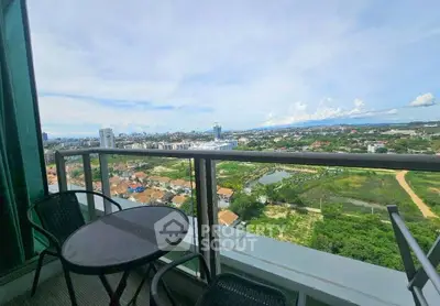 Stunning high-rise balcony view overlooking cityscape and lush greenery, perfect for relaxation.