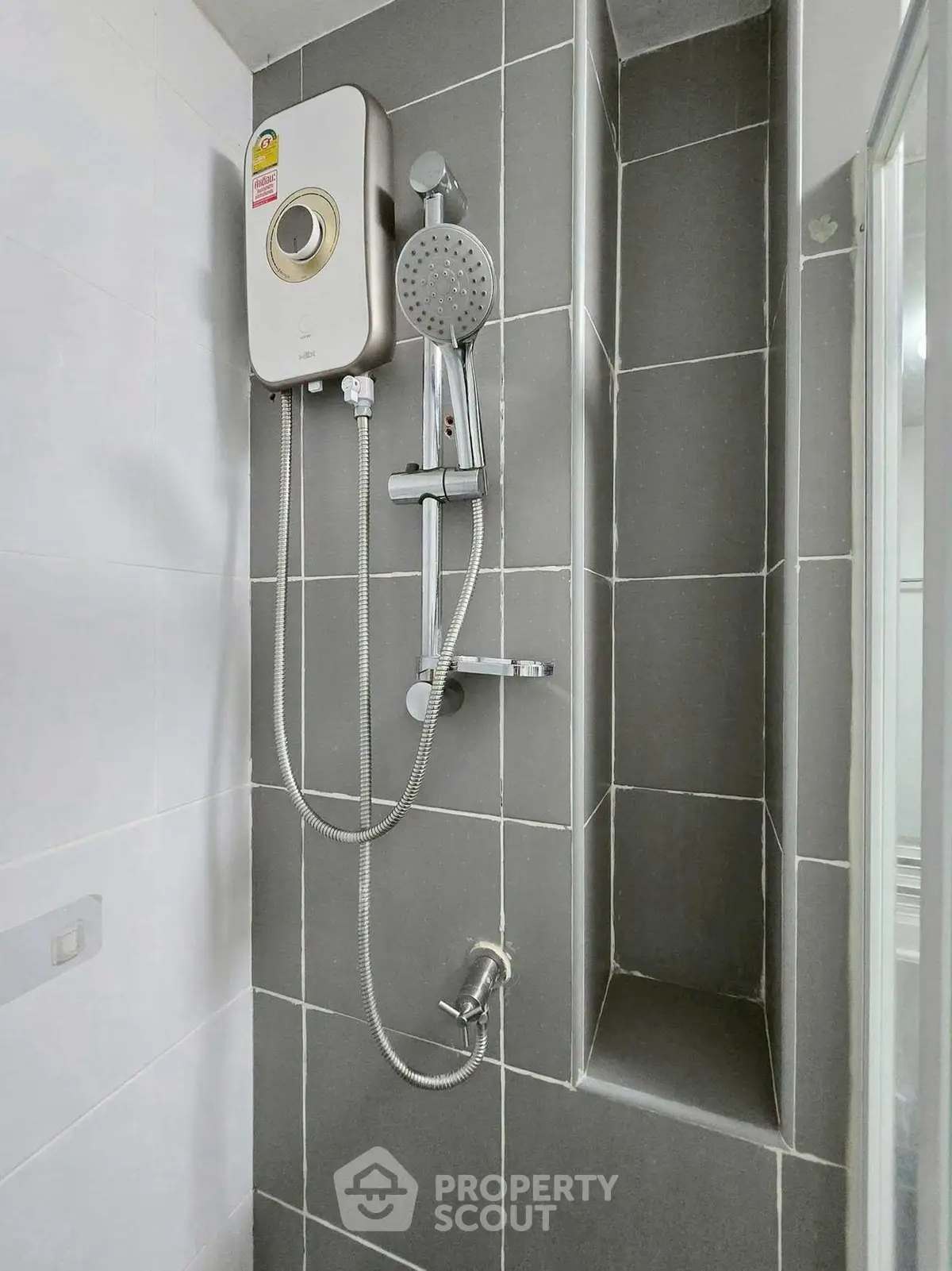 Modern bathroom shower with sleek gray tiles and water heater