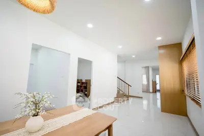 Spacious modern living area with elegant wooden accents and bright natural lighting.
