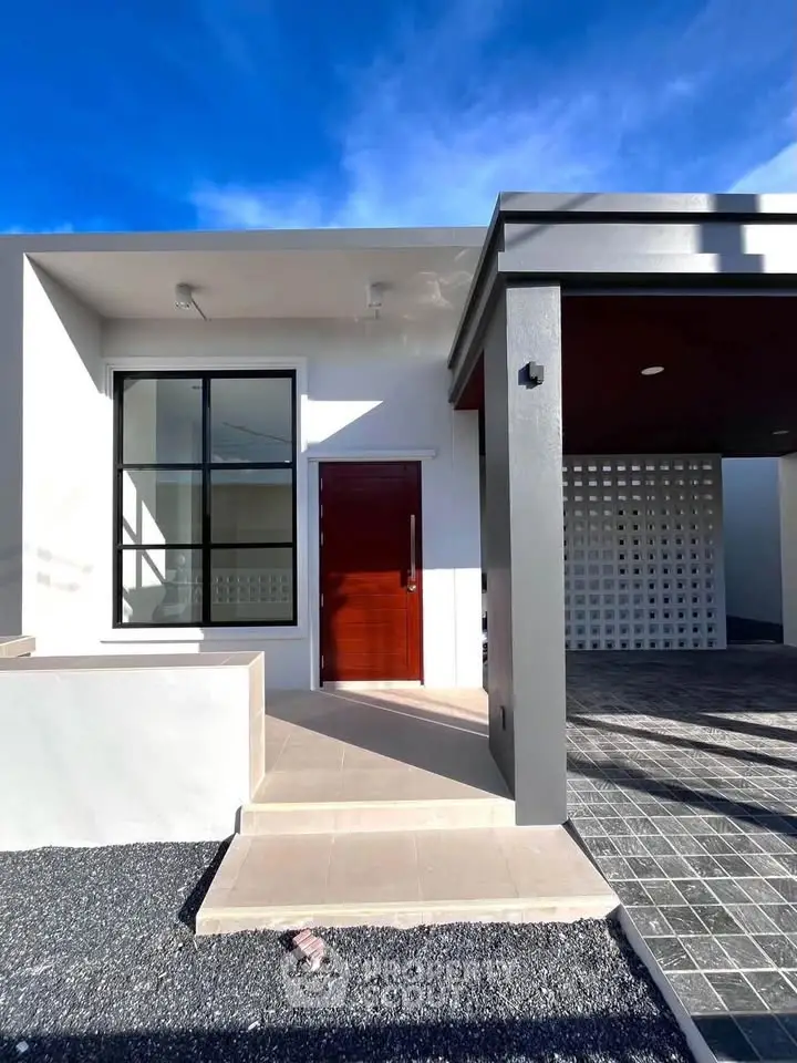Modern minimalist house exterior with sleek design and large window, showcasing contemporary architecture.