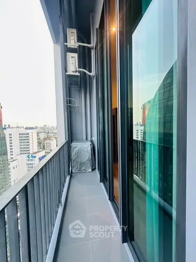 Modern high-rise balcony with city view and glass sliding doors