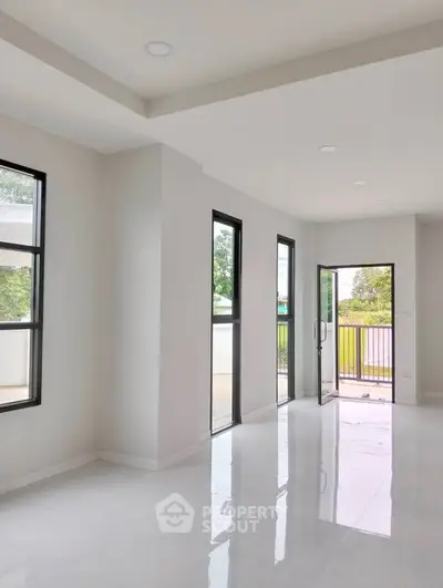 Spacious modern living room with large windows and balcony access