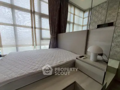 Modern bedroom with large windows and stylish decor in a luxury apartment.
