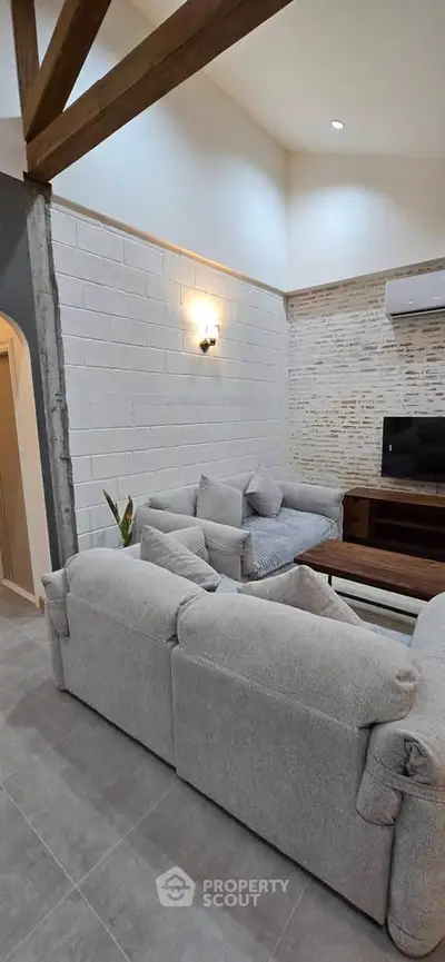 Modern living room with stylish exposed beams and cozy seating area.