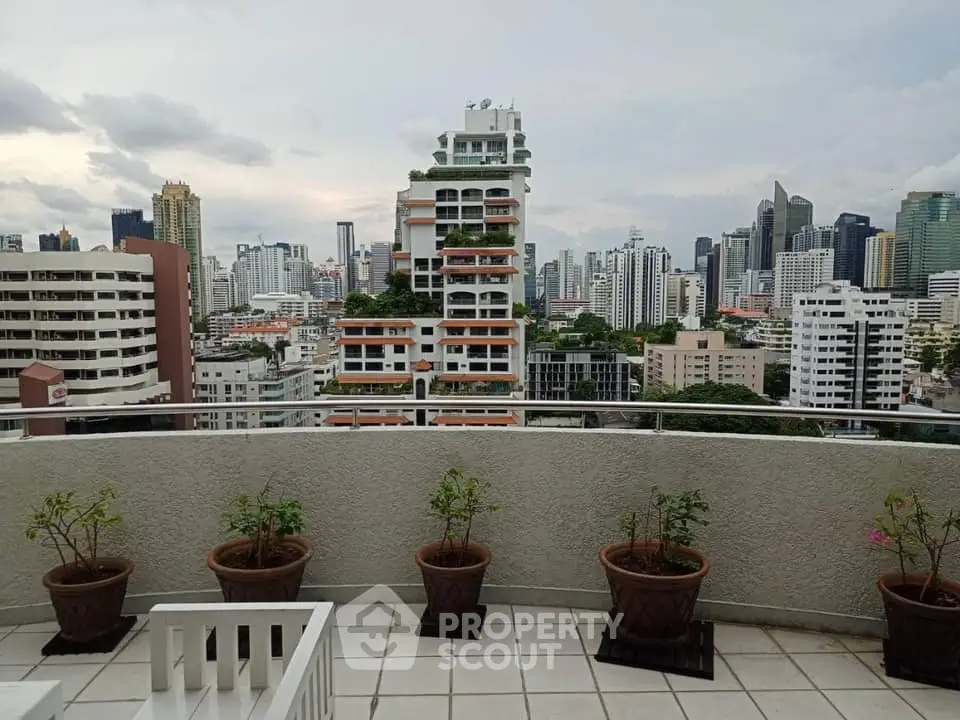 Stunning cityscape view from a spacious balcony with potted plants, perfect for urban living.