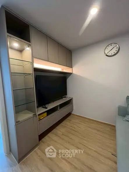 Modern living room with sleek entertainment unit and wall clock