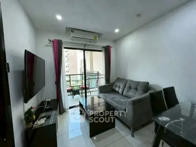 Modern living room with balcony view, stylish furniture, and natural light.