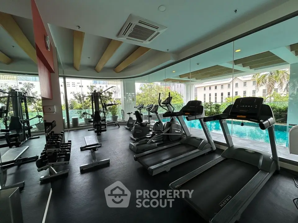 Modern gym with pool view in luxury residential building