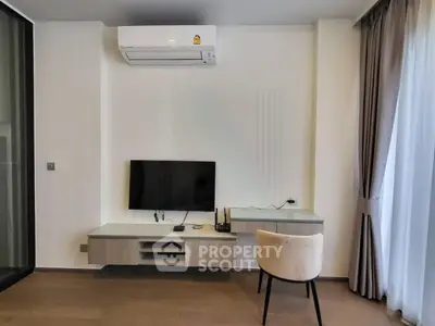 Modern living room with sleek TV setup and air conditioning, featuring elegant curtains and wooden flooring.