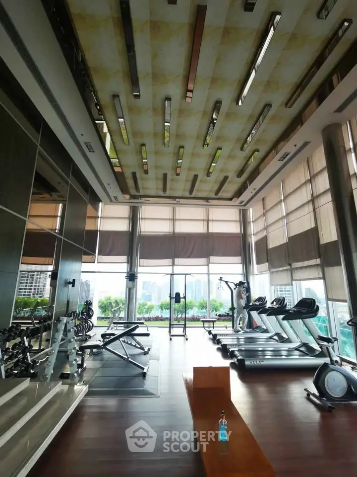 Luxurious gym with modern equipment and city view, perfect for fitness enthusiasts.