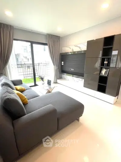 Modern living room with sleek furniture and large windows offering natural light and garden view.