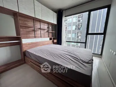 Modern bedroom with large window and stylish wooden furniture