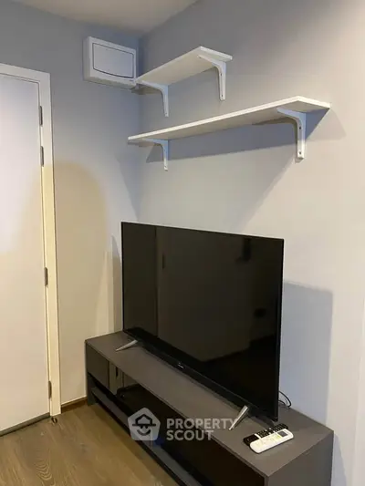 Modern living room with sleek TV stand and wall-mounted shelves