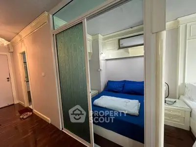 Cozy bedroom with sliding glass door and blue bedding in modern apartment