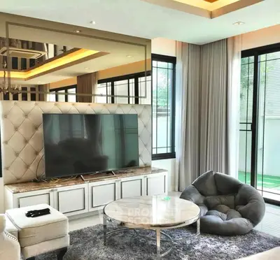 Luxurious living room with modern decor and large TV, perfect for relaxation.