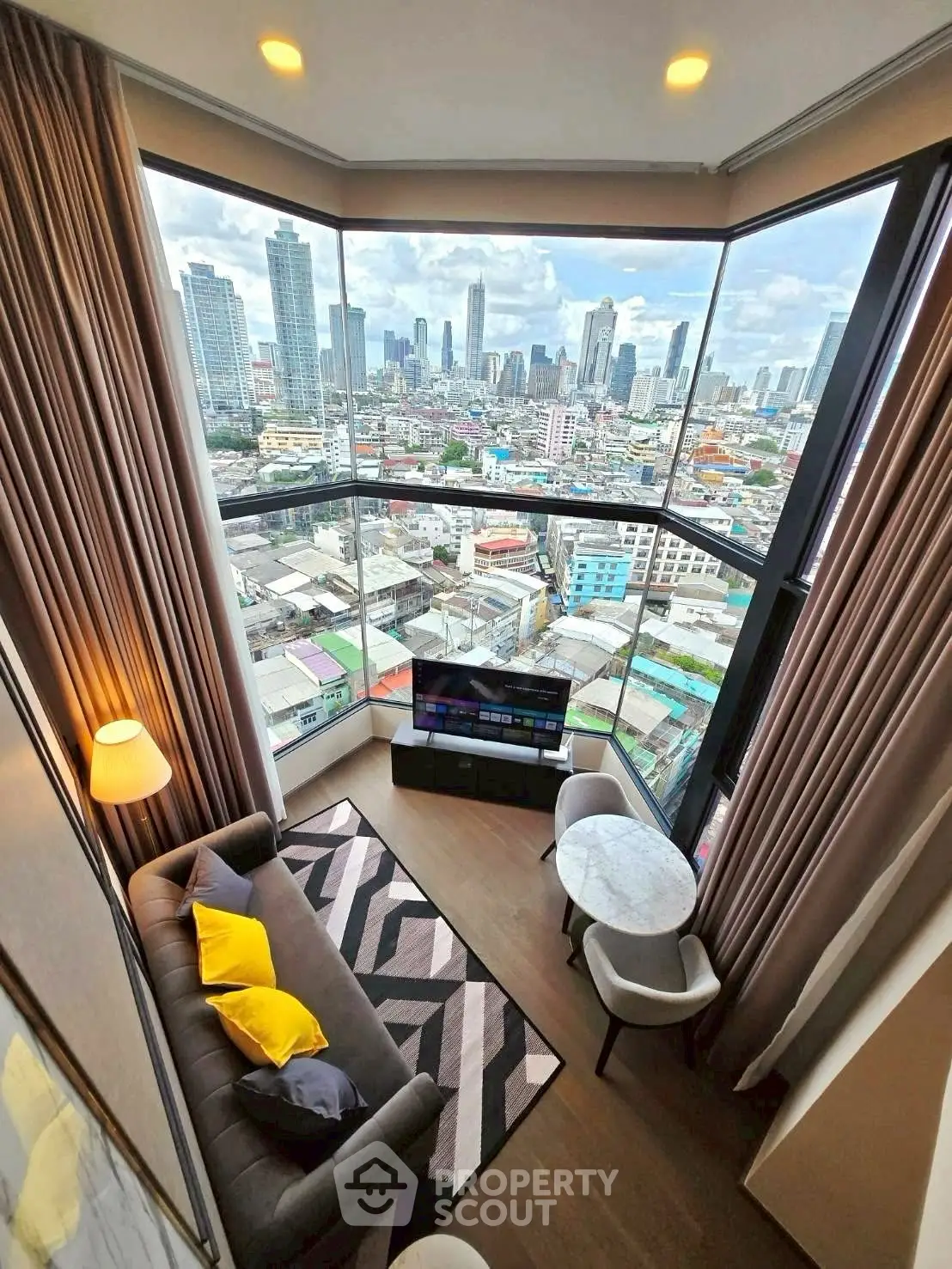 Stunning corner unit living room with panoramic city views and modern decor.