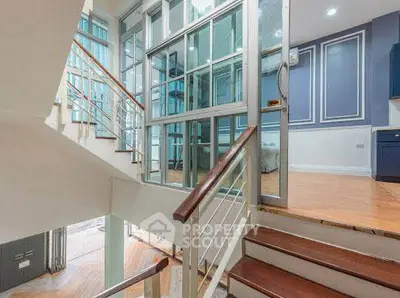 Spacious modern interior with elegant staircase and glass partitions