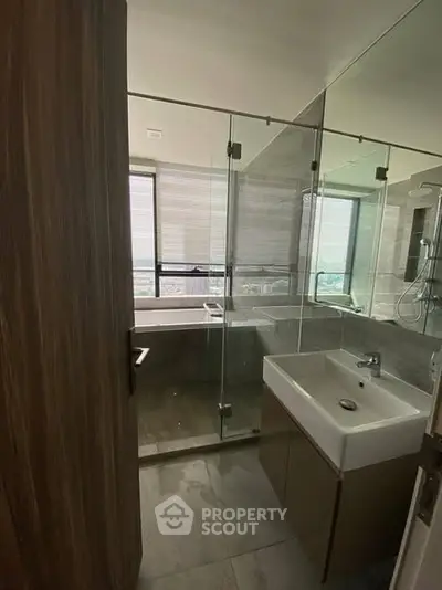 Modern bathroom with glass shower and city view