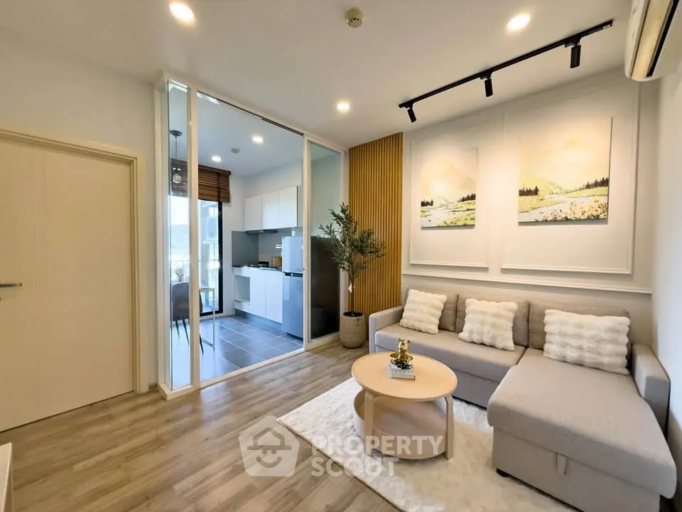 Modern living room with cozy sectional sofa and open kitchen layout in stylish apartment.