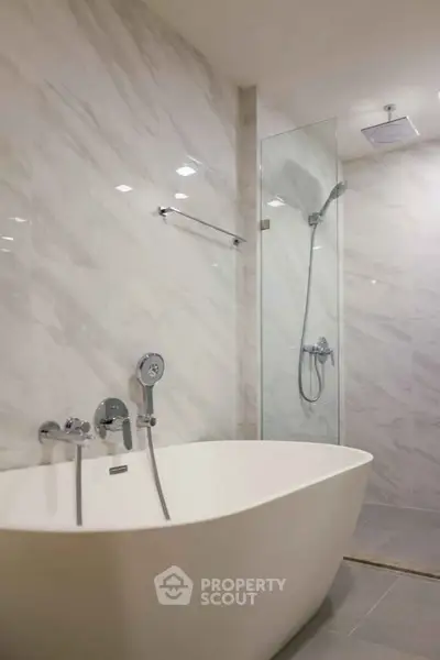 Luxurious bathroom with modern freestanding bathtub and elegant shower area.