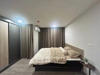 Modern bedroom with cozy bedding and stylish curtains in a contemporary apartment.