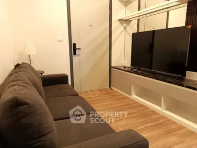 Cozy living room with modern sofa and large TV, perfect for relaxation.