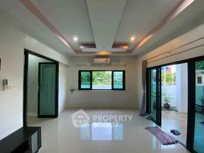 Spacious living room with modern ceiling design and large windows