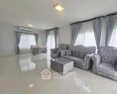 Spacious living room with elegant gray furniture and large windows for natural light.