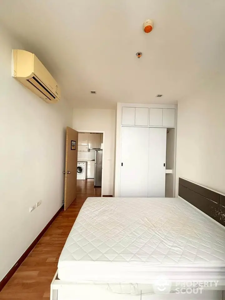 Spacious bedroom with built-in wardrobe and air conditioning in modern apartment