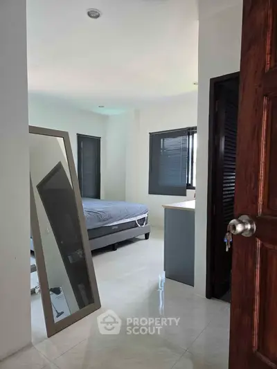 Spacious bedroom with modern decor and large mirror, perfect for comfortable living.