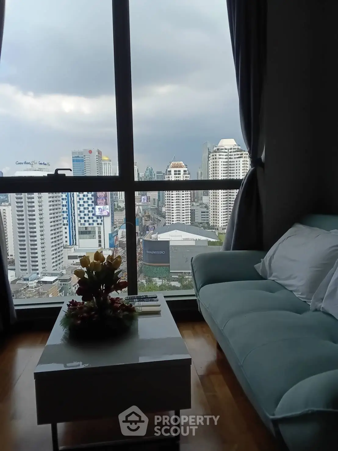Modern living room with stunning city view from high-rise apartment window.