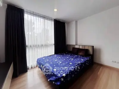 Spacious bedroom with large window and stylish decor in modern apartment
