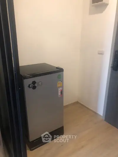 Compact storage area with a small refrigerator, ideal for efficient space utilization.