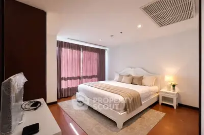 Spacious bedroom with elegant decor and natural light, featuring a cozy bed and stylish furnishings.