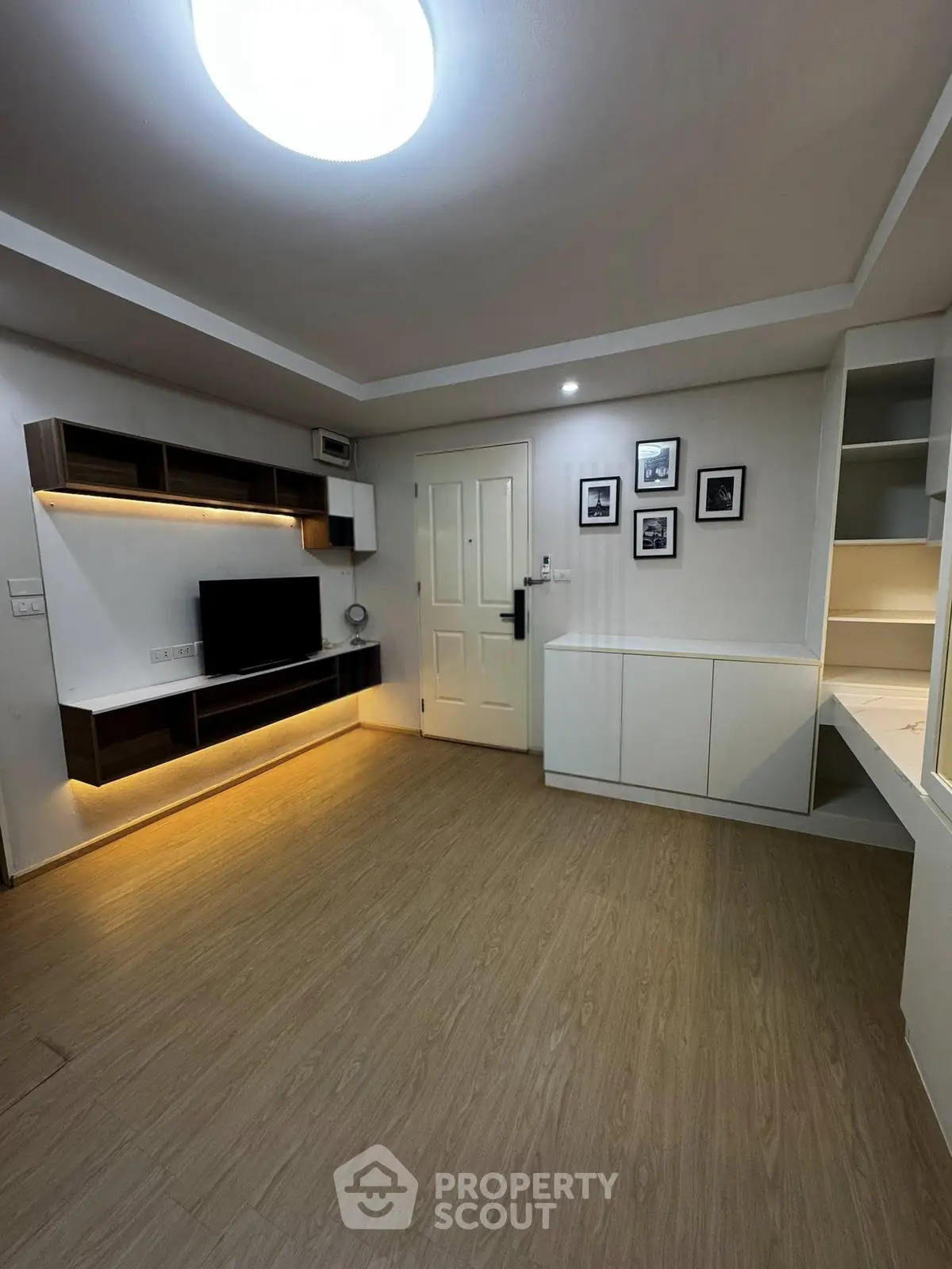Modern living room with sleek wooden flooring and built-in entertainment unit