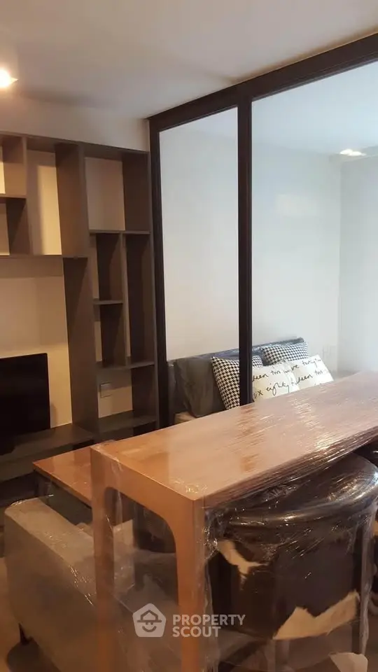 Modern living room with stylish furniture and glass partition, perfect for urban living.