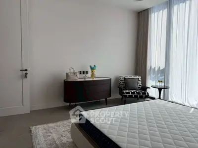 Modern bedroom with stylish furniture and large window for natural light.